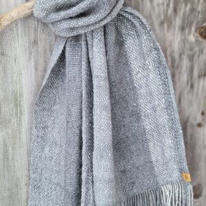 Håndvevd angoraskjerf drapert på en trepinne